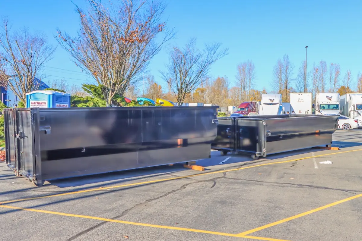 Professional dumpster rental service with roll-off container on residential driveway in Great Neck Plaza